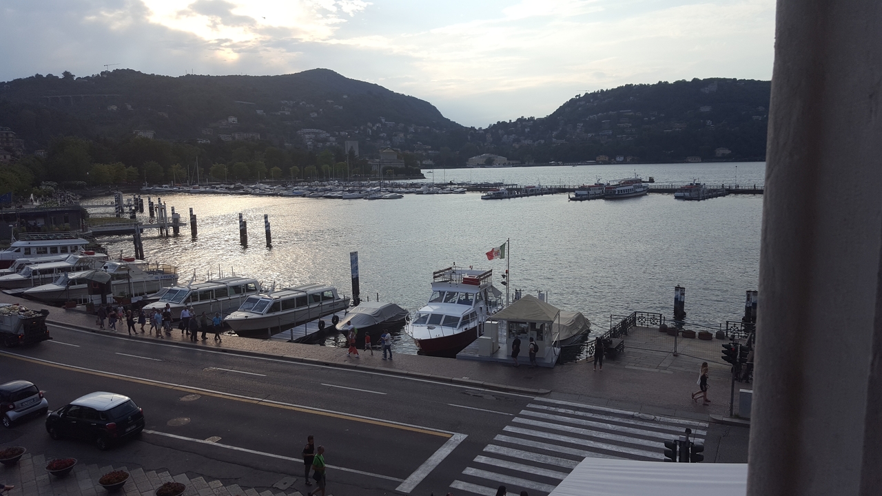 Une vue pittoresque d'un lac avec des bateaux et des montagnes en arrière-plan.