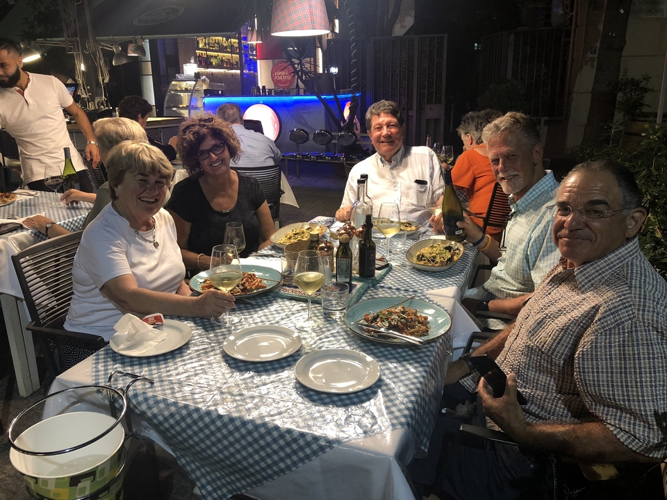 Groupe de personnes dînant dans un restaurant en plein air.