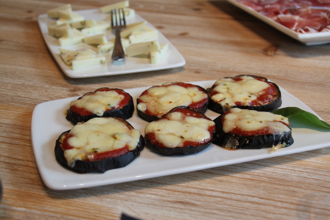 Assiette de tranches d'aubergines cuites au four avec du fromage sur une table en bois.