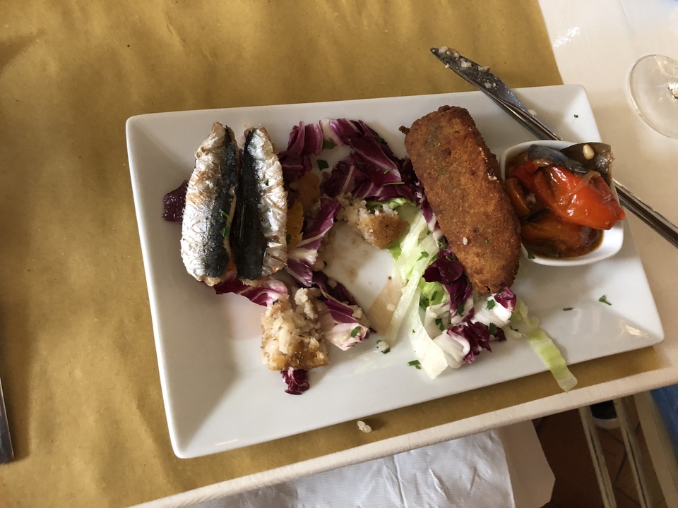 Assiette avec poisson grillé, salade et aliment pané.