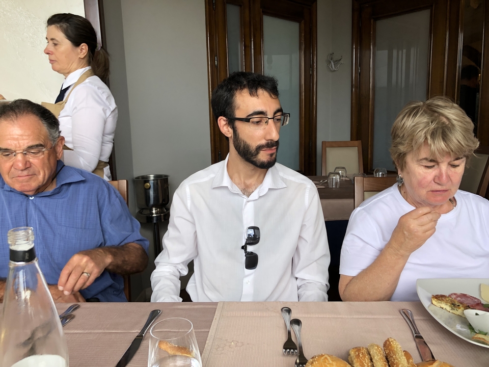 Trois personnes assises à une table de salle à manger prenant un repas avec plaisir.