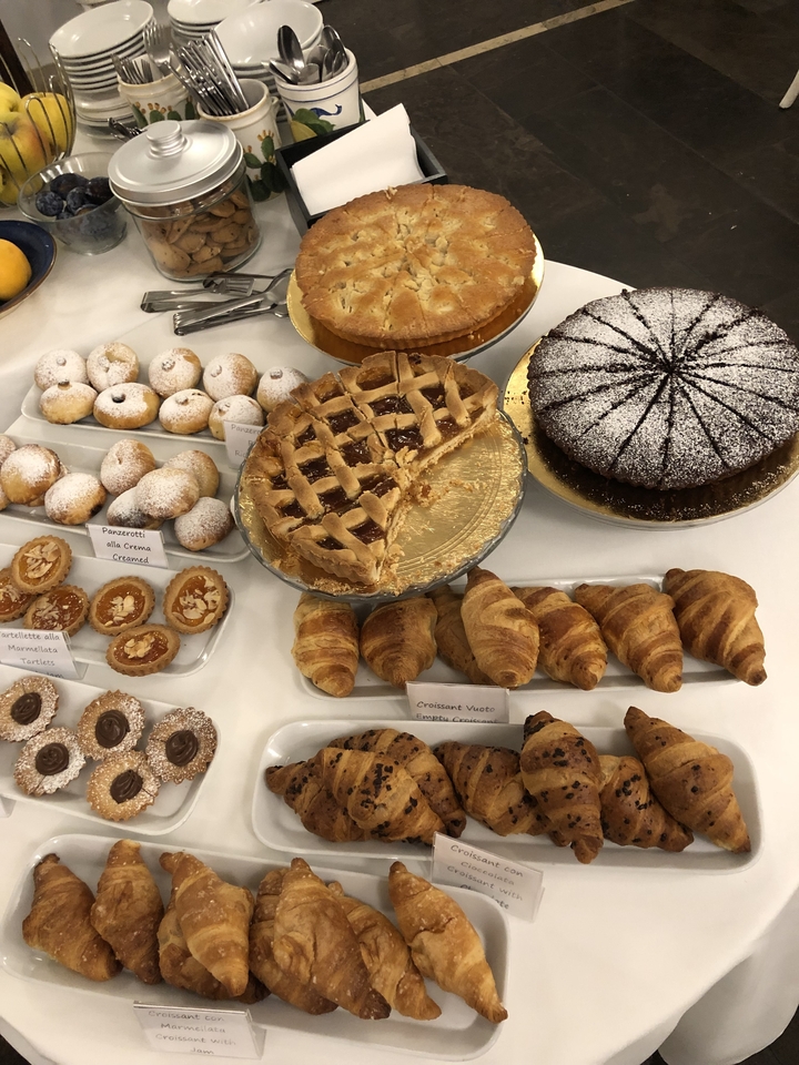 Diverses pâtisseries incluant des croissants et une tarte à treillis.