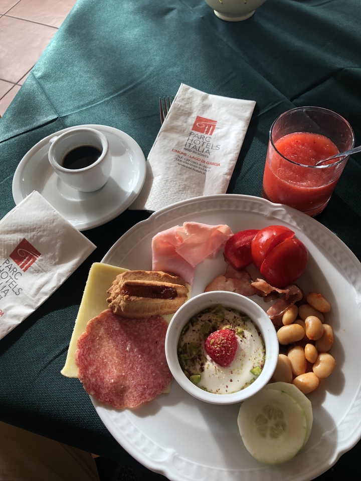 Petit-déjeuner composé de charcuterie, pain et boissons.