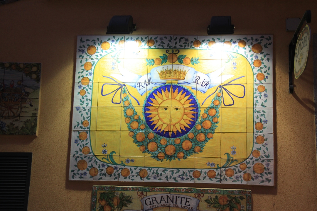 Fresque murale de carreaux décoratifs colorés avec un motif de soleil et couronne.