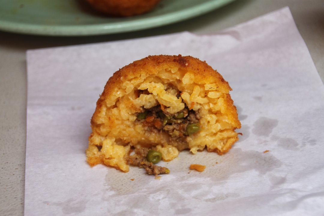 Onigiri à moitié mangé avec garniture de petits pois et viande.