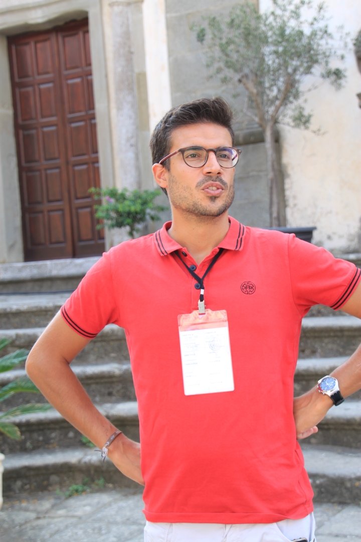 Homme avec un insigne parlant à l'extérieur.