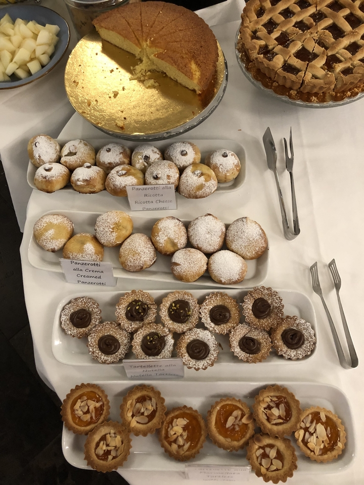 Pâtisseries assorties avec étiquettes indiquant les garnitures à la ricotta et à la crème.