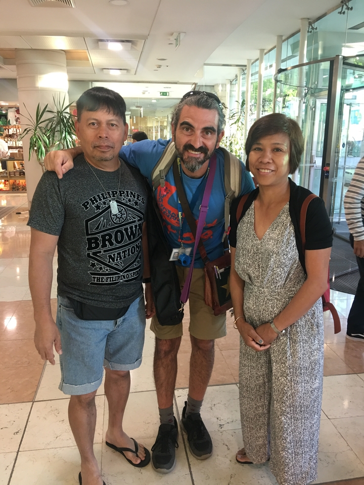 Trois personnes posant à l'intérieur dont une porte un t-shirt graphique.