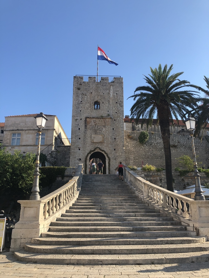 Entrée en pierre d'un bâtiment historique avec escaliers.