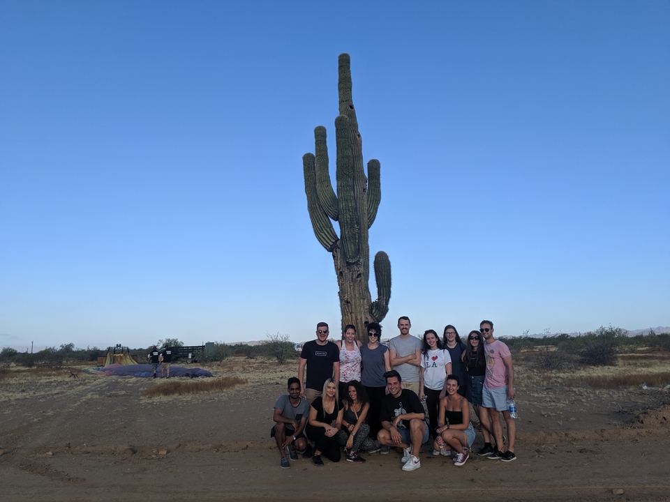 Groupe de personnes devant un grand cactus.