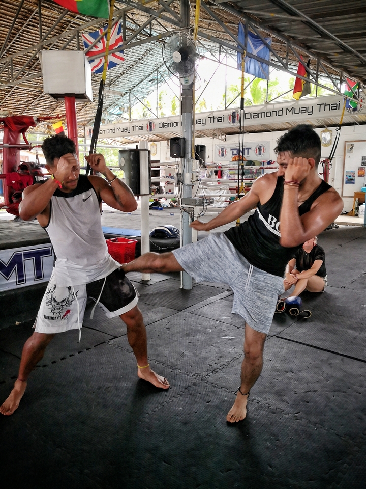Two men practicing martial arts in a gym.