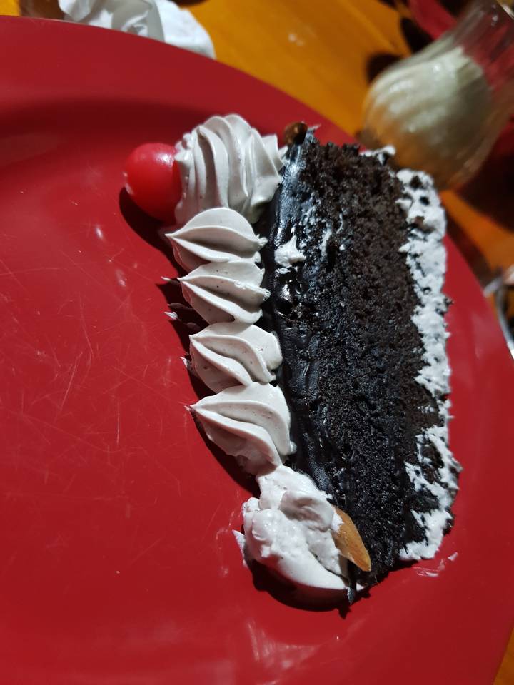Une tranche de gâteau au chocolat sur une assiette rouge.