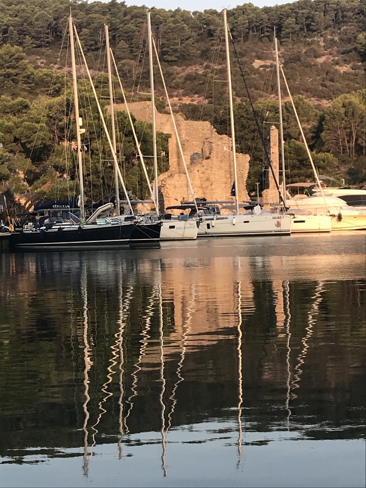 Yachts amarrés près d'un ancien bâtiment en pierre.