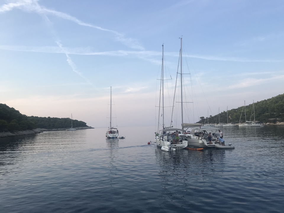 Voiliers sur des eaux calmes avec des personnes à bord.