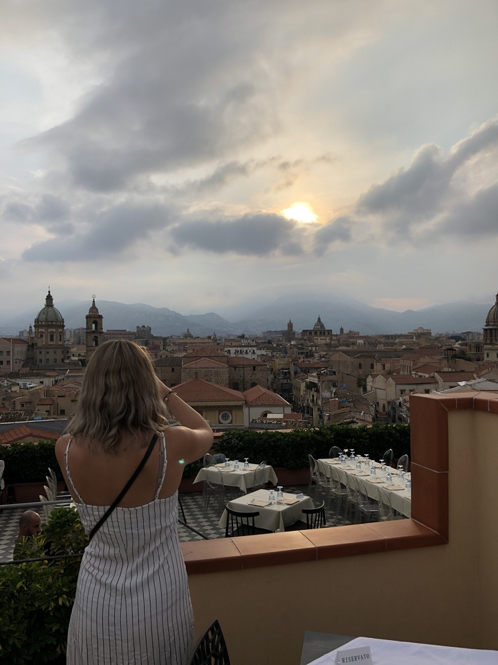 Personne contemplant un paysage urbain avec des bâtiments historiques.