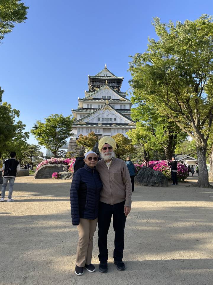 Deux personnes posant devant un château japonais.