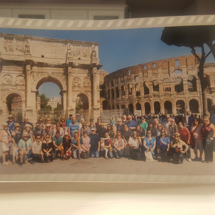 Grand groupe de touristes posant devant le Colisée.