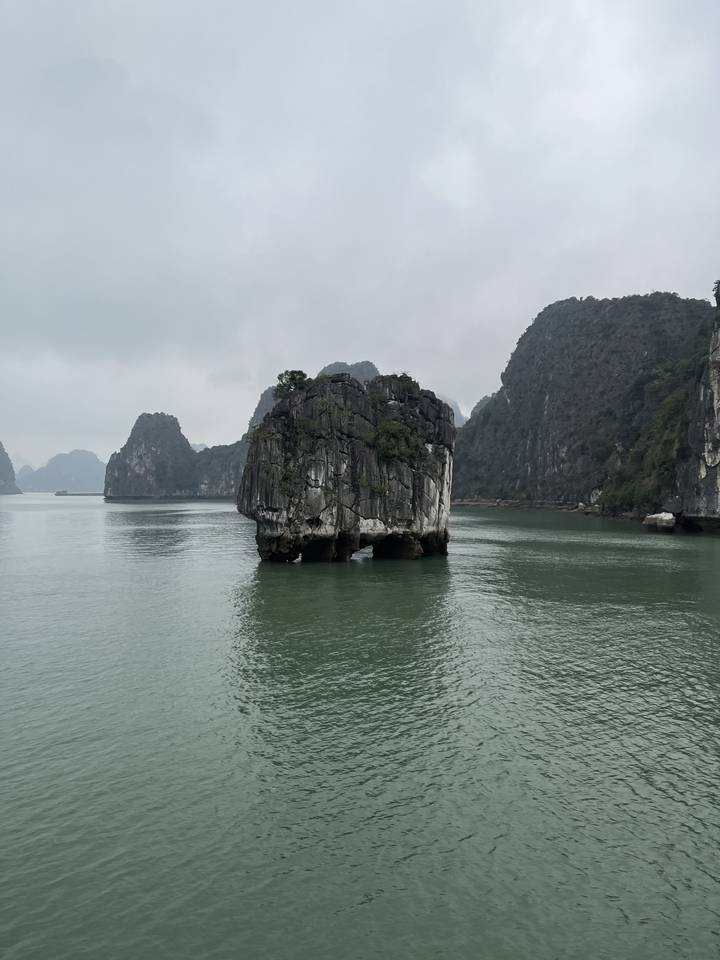Formation rocheuse pittoresque dans la mer avec des montagnes brumeuses.