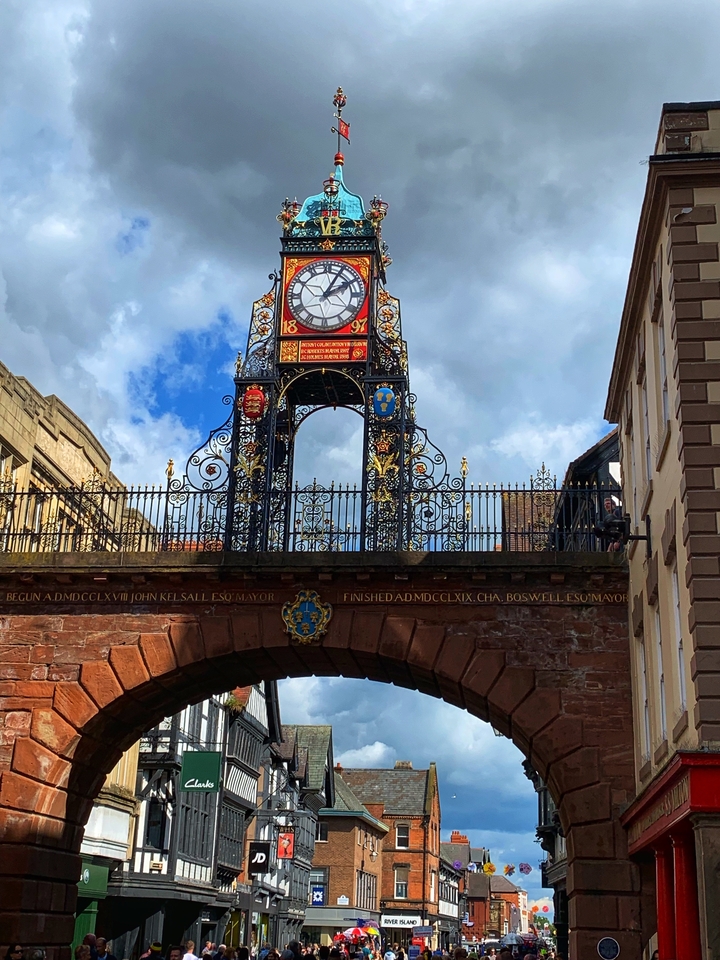 Une tour d'horloge décorative avec une ferronnerie complexe sur fond de ciel bleu.