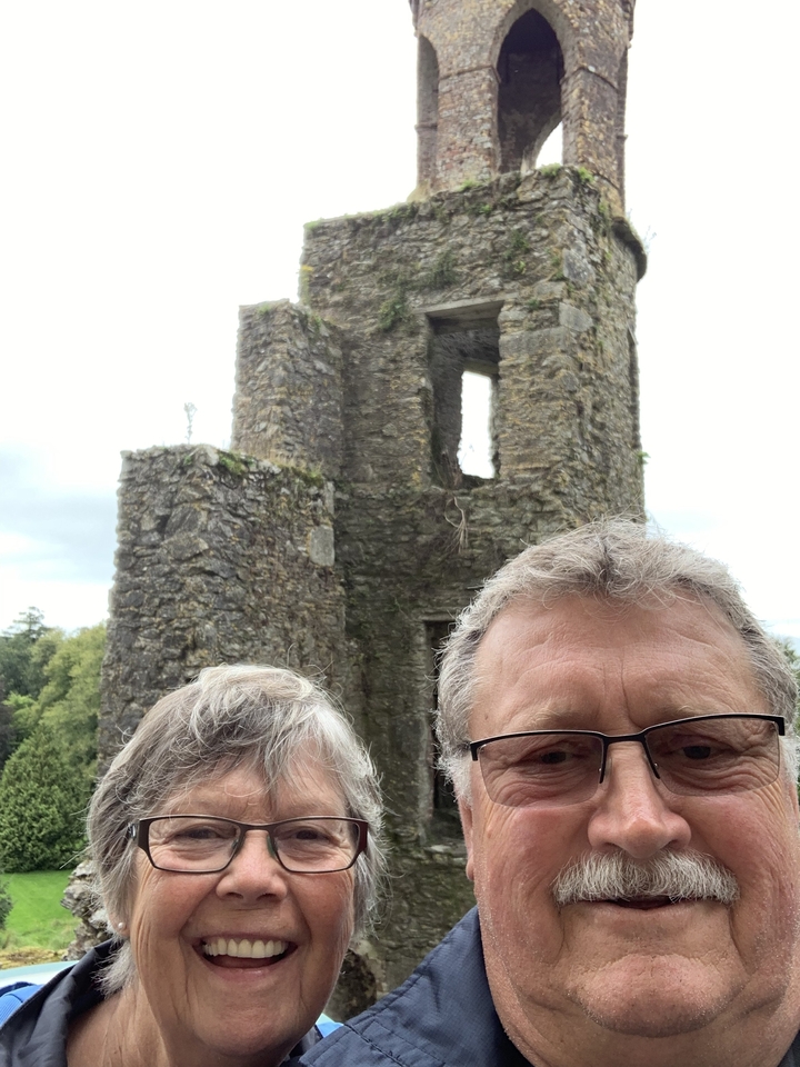 Un selfie avec des ruines de pierre en arrière-plan.