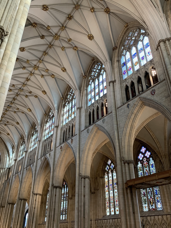 Intérieur d'une cathédrale avec des vitraux et des voûtes.