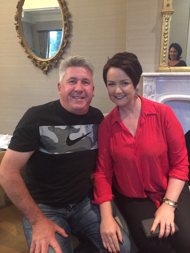 Deux personnes posant à l'intérieur en tenue décontractée.