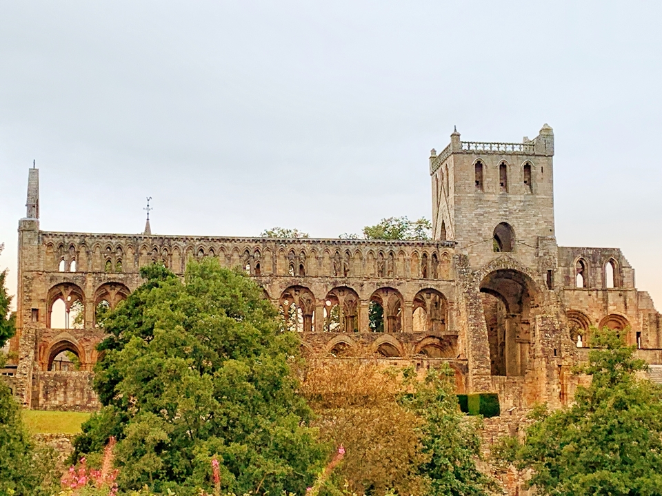 Ruines d'un grand bâtiment historique entouré de verdure.