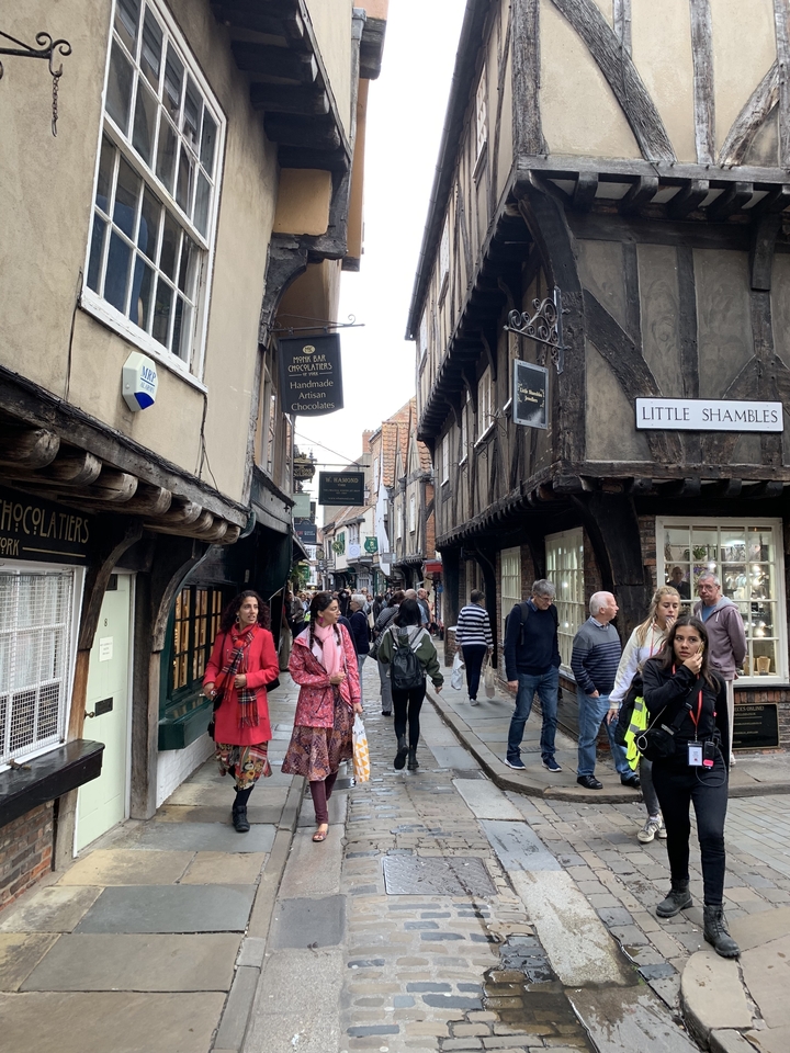 Une rue commerçante animée avec des bâtiments historiques et des gens qui marchent.