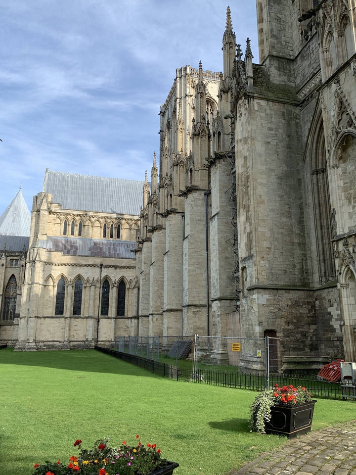 Vue extérieure d'une cathédrale historique avec des arcs-boutants et des fenêtres.