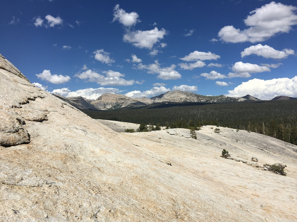 Paysage étendu avec un terrain rocheux et des montagnes au loin.