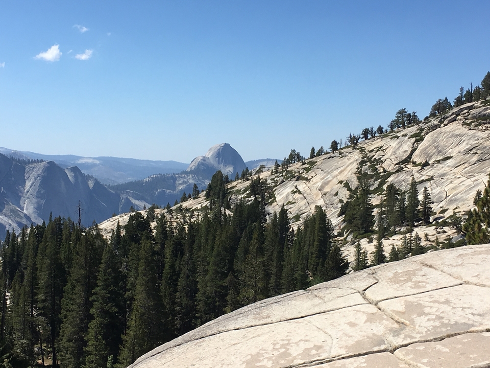 Montagnes de granit avec des forêts et une vue lointaine du Half Dome.