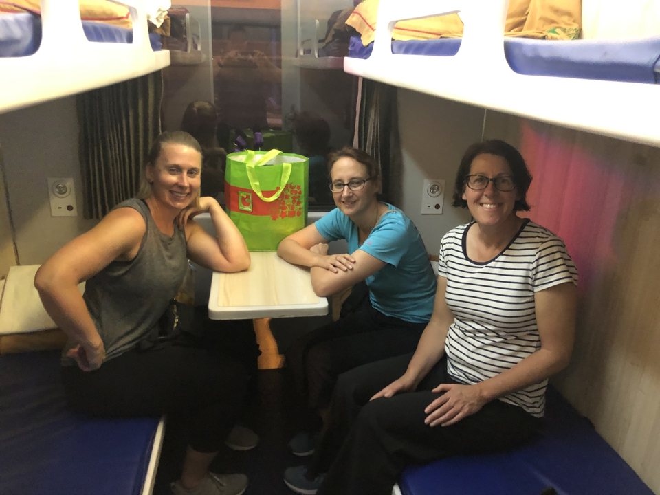 Trois femmes assises à une table dans un compartiment de train.