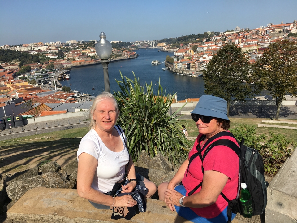 Deux femmes assises avec vue sur une ville et une rivière.