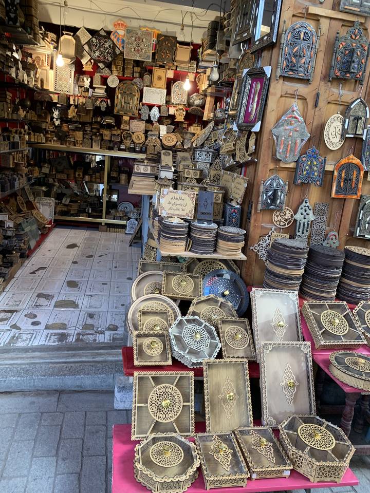 Étal de marché présentant de l'artisanat et des ornements en métal.