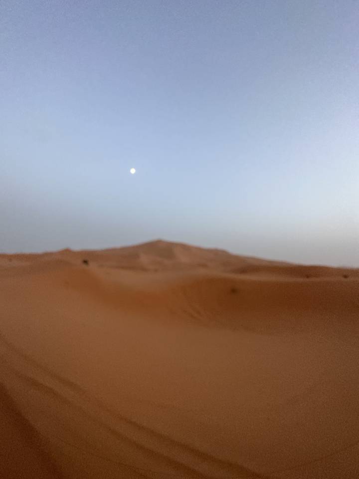 Dunes de sable dans un désert avec un ciel nuageux.