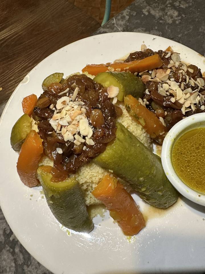 Assiette de nourriture traditionnelle avec légumes et sauce.