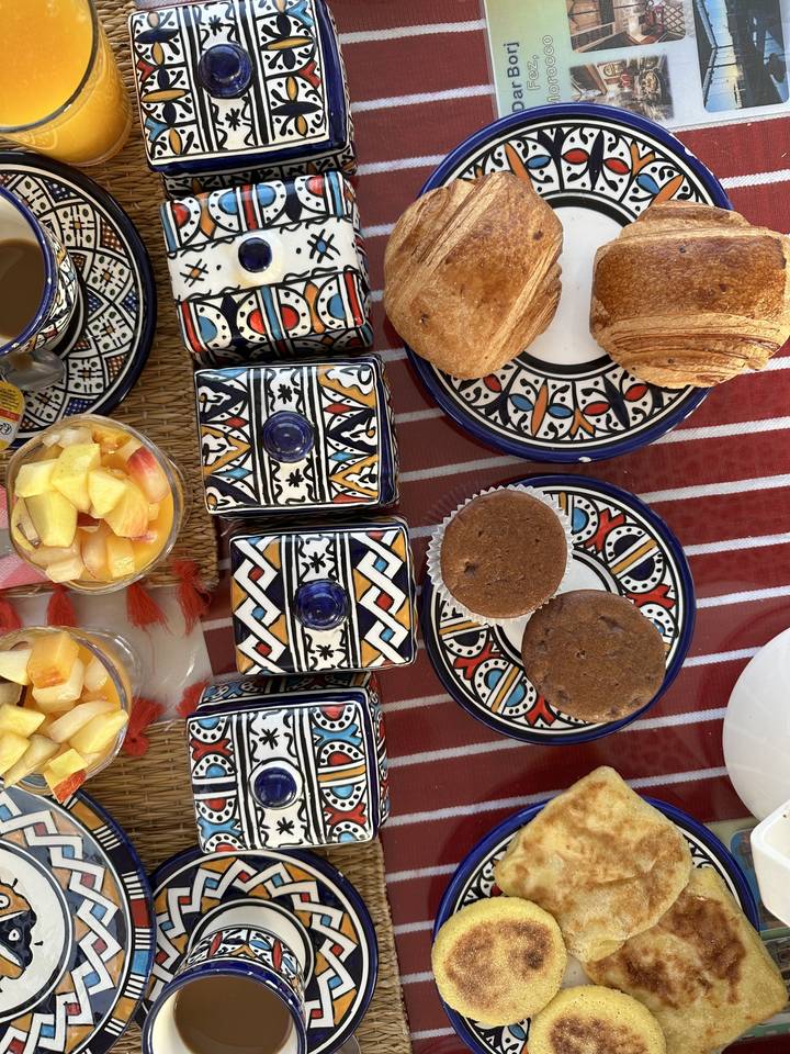 Assortiment de plats traditionnels marocains dans des assiettes colorées.