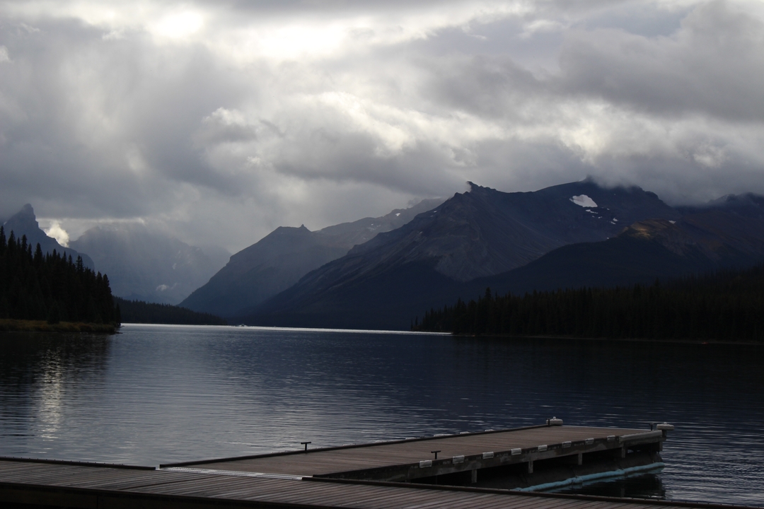 Lac avec des montagnes au loin et un ponton.
