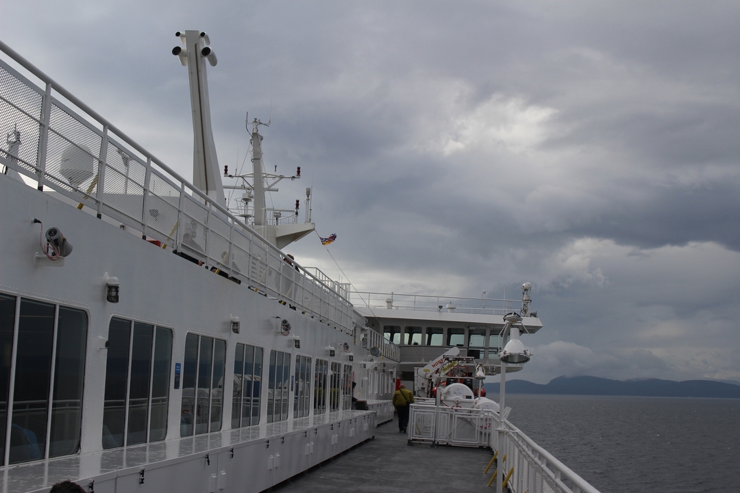 Grand navire sur l'eau sous un ciel nuageux.