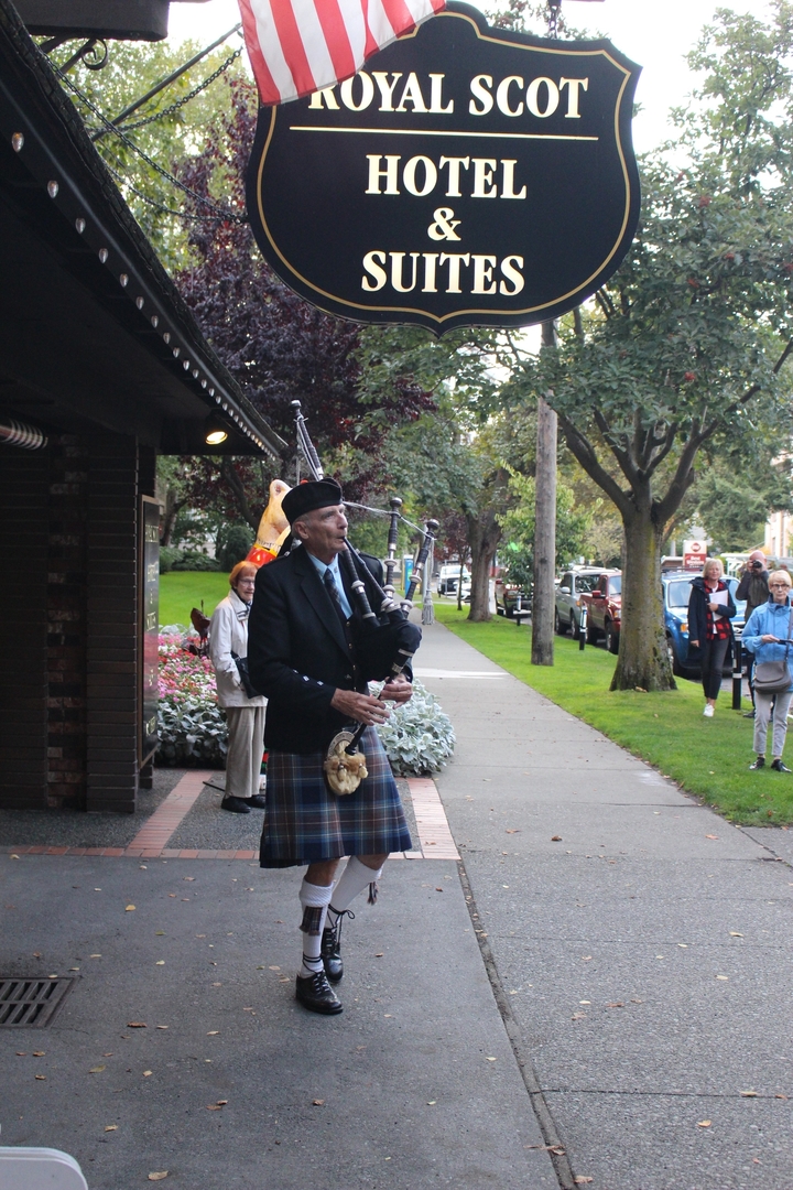 Homme jouant de la cornemuse sur le trottoir.