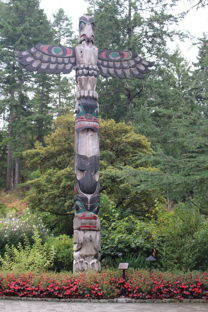 Mât totémique entouré d'arbres de la forêt.