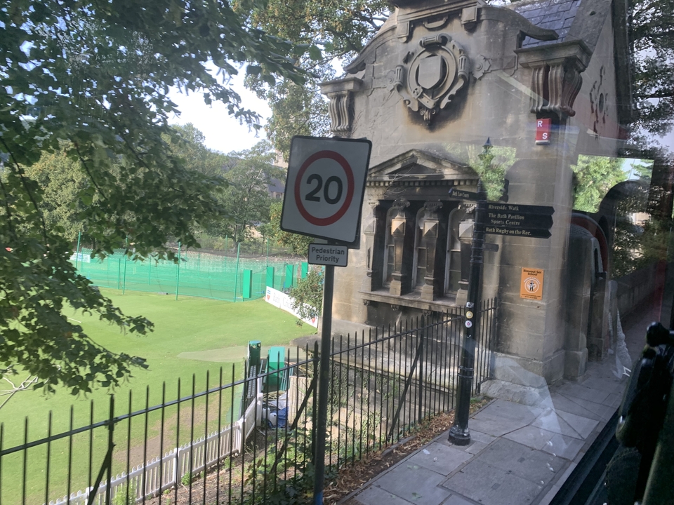 Un panneau de priorité aux piétons près d'un terrain de sport.