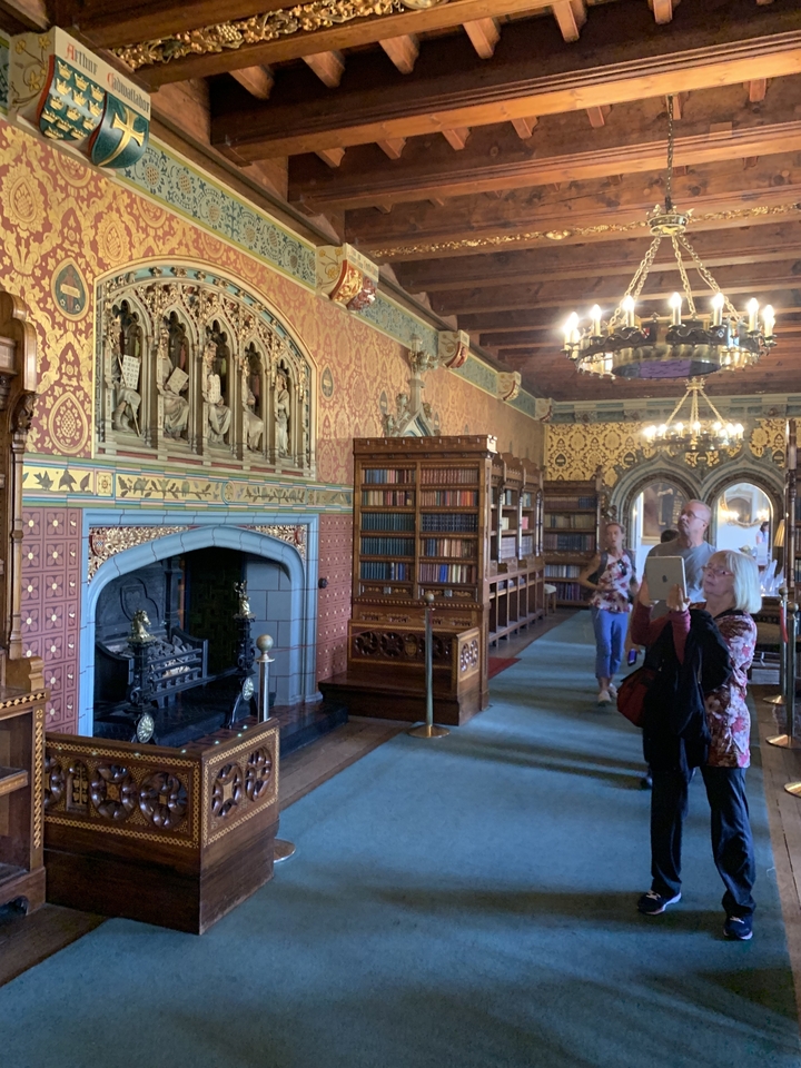 Des personnes prenant des photos dans un cadre de bibliothèque historique.
