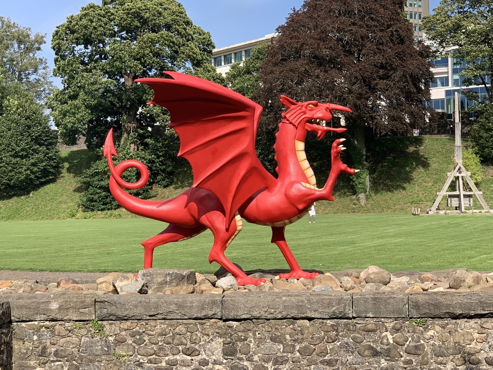 Une sculpture de dragon rouge dans un parc.