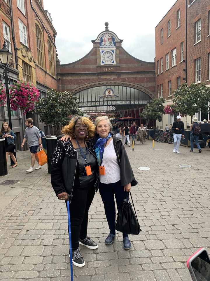 Deux femmes posant devant l'entrée d'un marché historique.