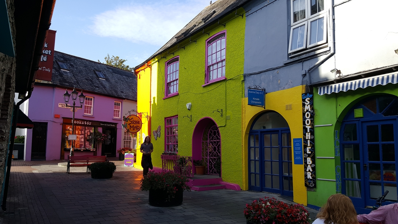 Bâtiments colorés dans une vue de rue avec des piétons.