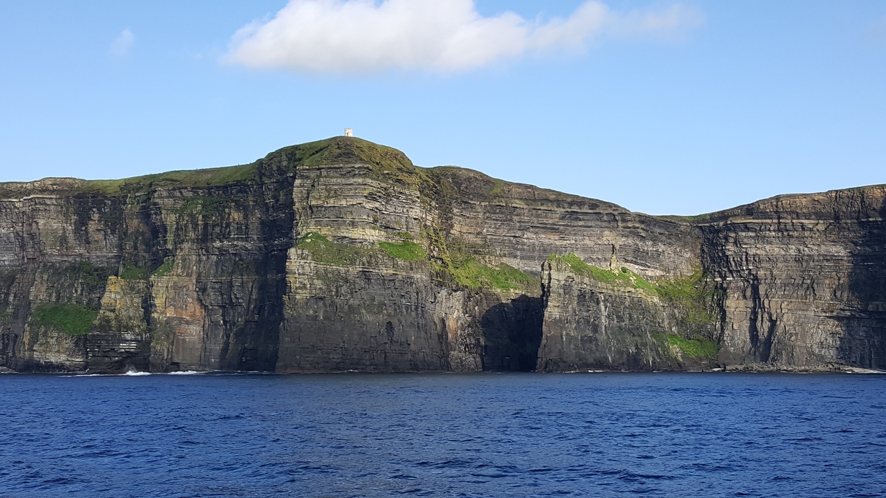 Falaises avec un petit bâtiment au sommet et vue sur l'océan.