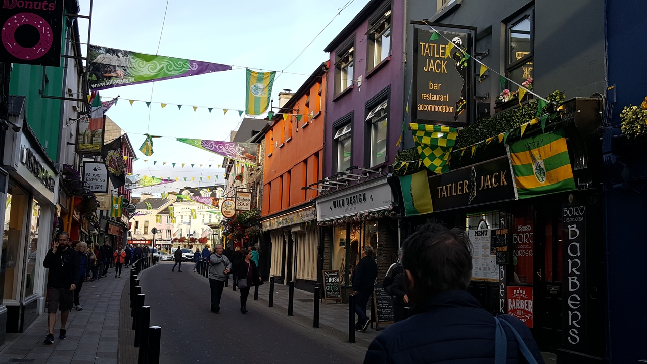 Une rue colorée avec des magasins et des drapeaux décoratifs.