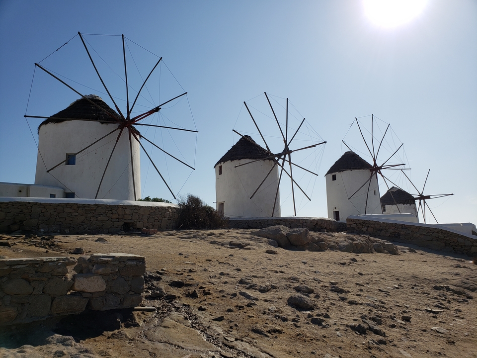 Moulins à vent traditionnels sur une colline sous un ciel dégagé.