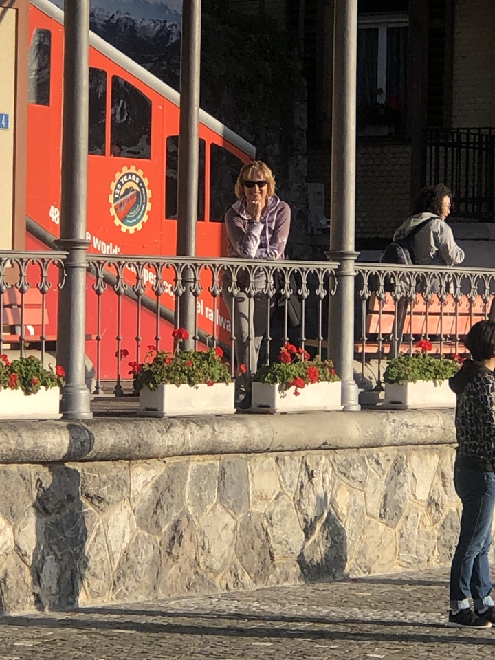 Personne debout sur le trottoir avec des fleurs dans des jardinières.